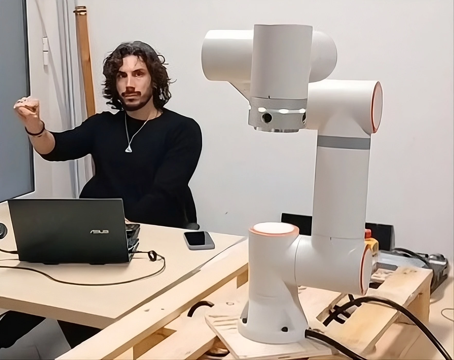 Interazione uomo-robot: operatore e braccio robotico.